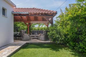 卡什泰拉Villa Lado with private pool near Split的一个带椅子的庭院和木制凉亭