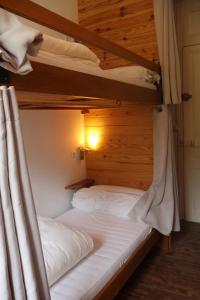吕兹-圣索沃尔Solfé Backpacker的卧室配有2张双层床和白色床单