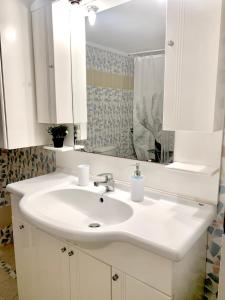 海若克利欧George Airport Apartments的浴室设有白色水槽和镜子