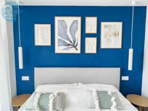 穆贾San Rocco Sweet Apartments的一间卧室设有蓝色的墙壁和一张带枕头的床。