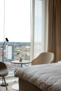 谢莱夫特奥The Wood Hotel by Elite, Spa & Resort的一间卧室配有床和椅子以及大窗户