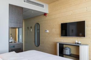 谢莱夫特奥The Wood Hotel by Elite, Spa & Resort的卧室设有木墙,配有平面电视。