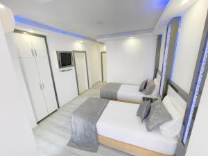 阿拉尼亚Livane Sun Otel的小房间设有两张床和电视