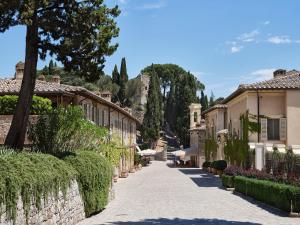 Castiglione del Bosco托斯卡尼瑰丽酒店的村里一条有房屋和树木的街道