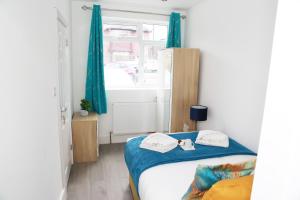 The HydeDeluxe 4 bedroom House的一间卧室配有一张带蓝色窗帘的床和一扇窗户
