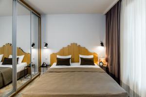 第比利斯Rasta Maidan Hotel的一间卧室配有一张大床和大型木制床头板