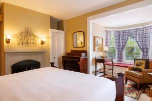 巴港米拉蒙特套房酒店的卧室配有白色的床和壁炉