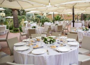 阿格里真托德拉瓦莱酒店的一张桌子,用来举办婚礼,上面有白色的桌子和椅子