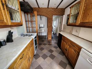 伯明翰Sheldon Shared House的厨房配有木制橱柜和炉灶烤箱。