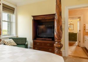 塔里敦城堡Spa酒店的木制娱乐中心设有带电视的卧室