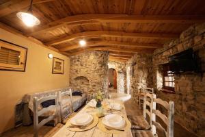 布雷拉Holiday home Raos - a special stonehouse, Brela的一间带桌椅和电视的用餐室
