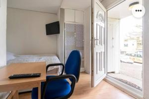 查塔姆Medway luxury Retreat free parking free wi-fi的客房设有一张带蓝色椅子的桌子和一张床