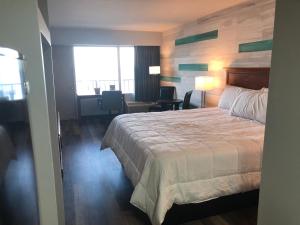 默特尔比奇Gazebo Inn Oceanfront的酒店客房设有一张大床和一张书桌。