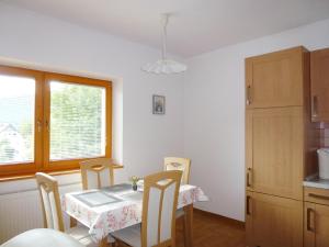 博希尼Apartment Jalps 1 in beautiful Bohinjska Bistrica的一间带桌椅和窗户的用餐室