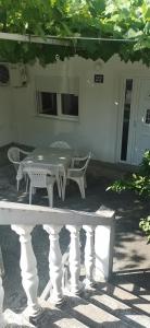 佩特罗瓦纳莫鲁Sobe i apartmani Marović的桌子和长凳在房子前面