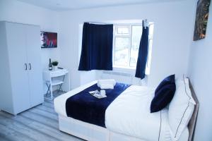 伦敦Lovely Apartment with free parking on premises.的一间卧室配有一张带蓝色毯子的床和窗户。