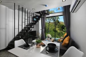 奈汉海滩Utopia Villa Naiharn Beach的一间带桌椅和楼梯的客厅