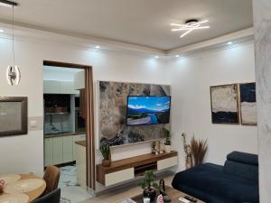 索科矿泉村HONEYMOON APARTMAN的客厅配有沙发和墙上的电视