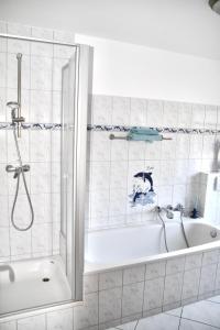 萨加尔德Ferienhaus-Fiete-2的白色的浴室设有浴缸和淋浴。