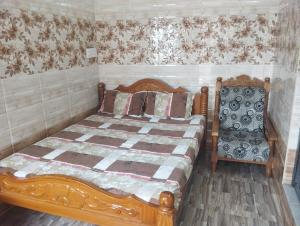 VelankanniNoah Home的一间卧室配有一张木床和一把椅子