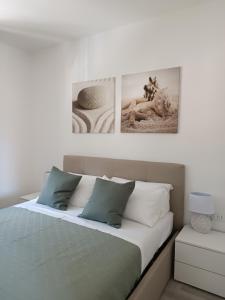 瓦拉泽GF Holiday Suite 3的卧室配有一张墙上有两张照片的床。
