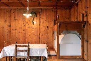 圣维托-迪卡多雷Appartamento La Tana sulle Dolomiti的客房设有一张桌子和一张双层床。