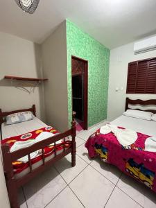 博尼图Pousada Vancele的一间卧室设有两张床和绿色的墙壁