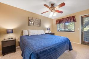 弗拉格斯塔夫Charming Walnut Hills Condo的一间卧室配有一张蓝色的床和吊扇
