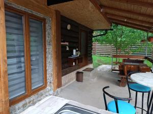 亚伊采Cottage Auto Camp Vinac的庭院配有桌椅和窗户。