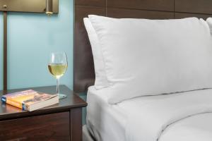 戈勒姆托普诺次酒店的睡床旁的桌子上放一杯葡萄酒