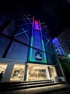 曼谷Grace At Five by Grace Hotel Bangkok的建筑上灯亮蓝色,绿光亮