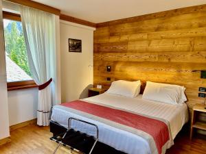 库马约尔可露克斯酒店的一间卧室设有一张床和木墙