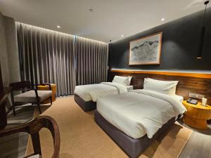 加德满都Hotel Barahi Kathmandu的酒店客房,配有两张床和椅子