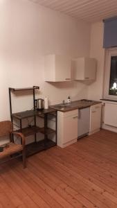 不莱梅Double Room with a Kitchen and a Shared Bathroom的厨房铺有木地板,配有白色橱柜。
