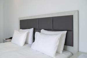 格拉斯托斯Giannoulaki Resort的一张带白色枕头的床和一个灰色床头板