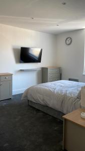 MoorsideChurch inn en-suite rooms with Wi-Fi的卧室配有一张床,墙上挂着一个钟