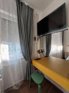 斯科普里Home Apartment LUNA的客房设有书桌、电视和绿椅