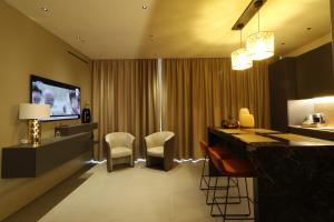 米斯泰尔比安科Giargeri Home的酒店客房设有带椅子和电视的酒吧。