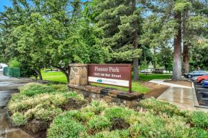本德Pioneer Park Rentals Downtown Bend的背景树木的护林公园标志