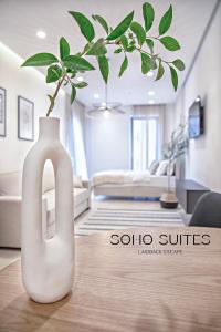 巴尔Soho Suites的客厅的一张桌子上的一个白色花瓶