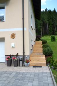 卢斯Apartma ob potoku的前面有楼梯和鲜花的建筑