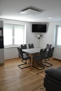 卢斯Apartma ob potoku的客房设有桌椅和平面电视。