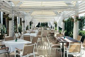 索佐波尔Sea Star Sozopol的一间设有白色桌椅和壁 ⁇ 的餐厅