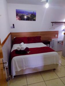 瓜拉派瑞Pousada Solar de Lourdes的一间卧室配有一张带红白毯子的床
