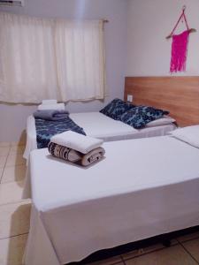 瓜拉派瑞Pousada Solar de Lourdes的客房内的两张床和毛巾