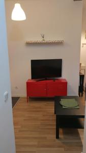马德里El pisito de Malasaña的客厅设有红色橱柜和平面电视