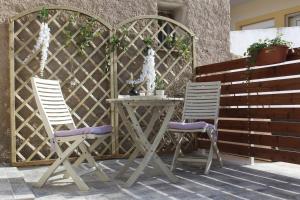希俄斯inHeart Apartment Chios的庭院里设有两把椅子和一张桌子