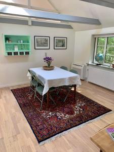 Hærvejshuset的一间位于地毯上的带桌椅的用餐室
