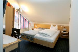 费尔德基希Schäfle Landgasthof的酒店客房配有一张床、一张书桌和一张四柱床