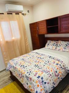 利伯维尔AS Guest House的一间卧室配有一张带花卉棉被的床和窗户。